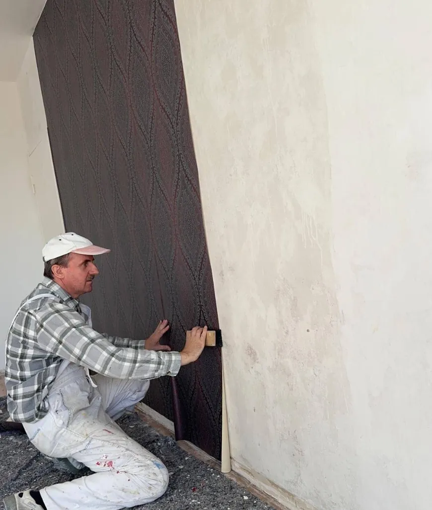 Tapete wird an einer Wand angebracht